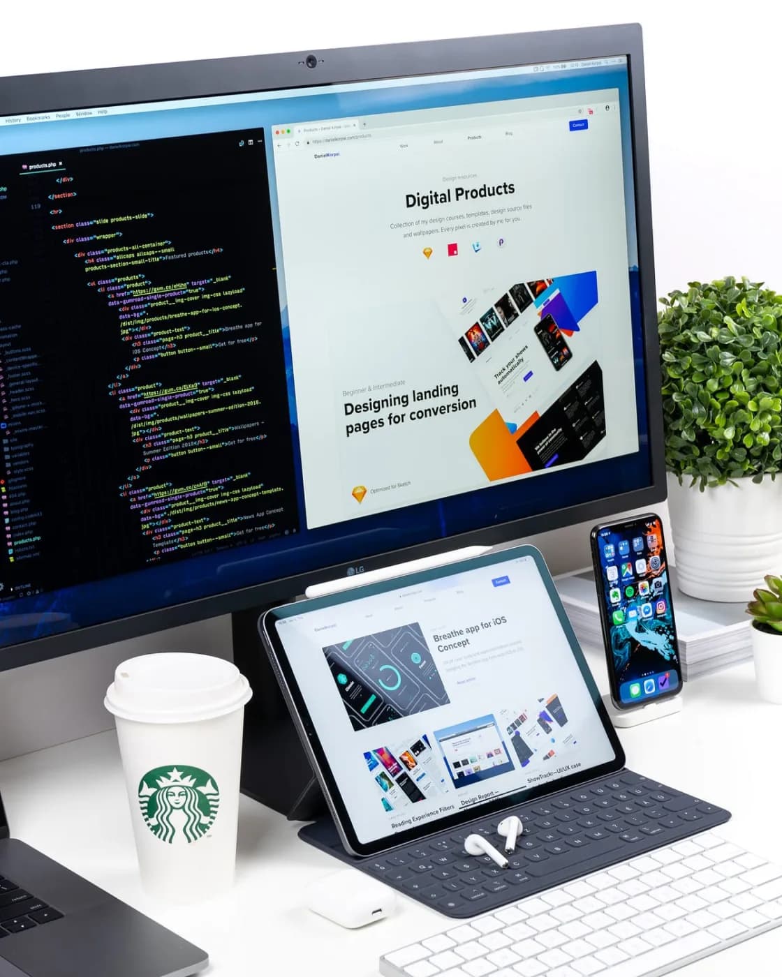 A developer desk with code on a monitor and a responsive site on tablet and phone